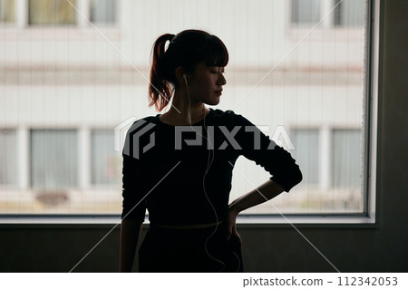 年輕女子一邊聽音樂一邊練習跳舞 112342053