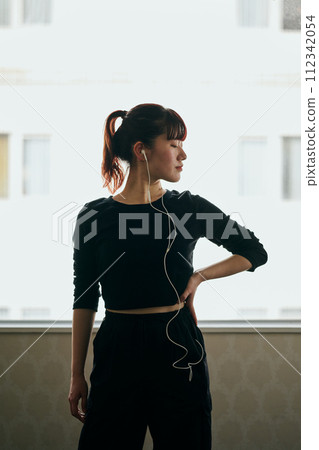 Young woman practicing dancing while listening to music Young woman practicing dancing while listening to music 112342054