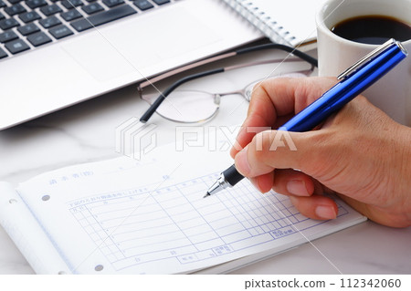 Image of a male hand writing an invoice by handwriting Image of a male hand writing an invoice by handwriting 112342060