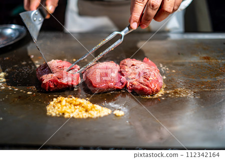 [#Teppanyaki] Chef's hand grilling steak meat 112342164
