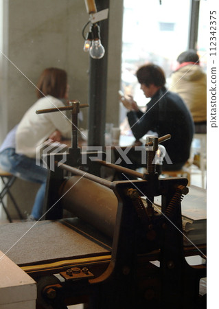 A coffee shop with a letterpress machine 112342375