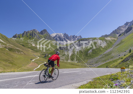 cyclist on route des Grandes Alpes near Col du Galibier, Hautes-Alpes, France 112342391