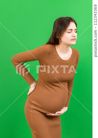 Pregnant woman with a pain in her back on colored Background isolated 112343369