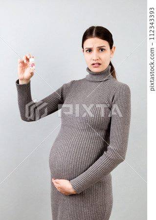 bottle of vitamin pills in pregnant woman's hand at colorful background with copy space. Healthcare concept 112343393