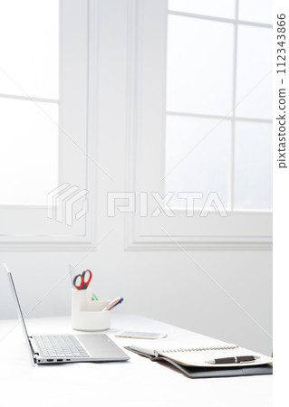 Image with a laptop and stationery next to a white window Image with a laptop and stationery next to a white window 112343866