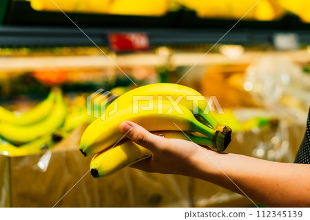 Boy holding a bunch of bananas in the supermarket Boy holding a bunch of bananas in the supermarket 112345139