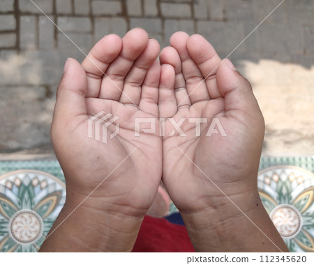 A small child's hands praying for blessings from god A small child's hands praying for blessings from god 112345620