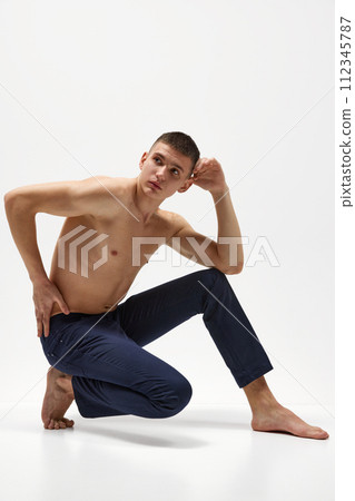 Handsome young man with short brunette hair, shirtless, muscular, relief body posing in jeans isolated over white studio background Handsome young man with short brunette hair, shirtless, muscular, relief body posing in jeans isolated over white studio background 112345787