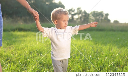 mother and baby a son walking in the park. happy family walking in the park in nature relaxing outdoors. happy family kid dream concept. mother and child lifestyle walking in the park mother and baby a son walking in the park. happy family walking in the park in nature relaxing outdoors. happy family kid dream concept. mother and child lifestyle walking in the park 112345815