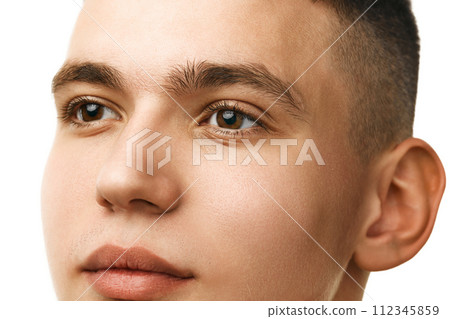 Close-up portrait of handsome young guy with smooth, shaved face, brown eyes and short hair isolated over white studio background Close-up portrait of handsome young guy with smooth, shaved face, brown eyes and short hair isolated over white studio background 112345859