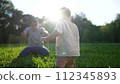 baby takes first steps in the park. happy family kid dream concept. dad teaches his son to walk takes the first steps lifestyle in the park on green grass. baby son taking first steps 112345893