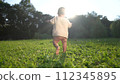 baby takes first steps in the park. happy family kid dream concept. dad teaches his son to walk takes the first steps in the park on lifestyle green grass. baby son taking first steps 112345895