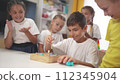child boy group playing fishing. a group of children collect building blocks in a kindergarten indoors. children in kindergarten play with toys. happy family kid lifestyle dream concept 112345904