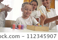 child group playing fishing lifestyle. children in kindergarten play with toys. happy family kid dream concept. a group of children collect building blocks in a kindergarten indoors 112345907