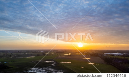 Dawn Breaking over Wet Fields with Cloudy Sky Dawn Breaking over Wet Fields with Cloudy Sky 112346616