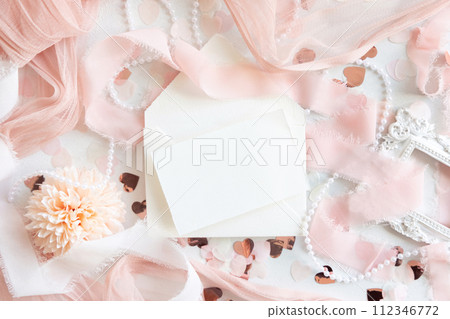 Card near pink decorations, hearts and silk ribbons on white table top view, mockup Card near pink decorations, hearts and silk ribbons on white table top view, mockup 112346772
