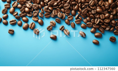 Coffee beans on a vibrant blue background, creating a cozy cafe ambiance. 112347560