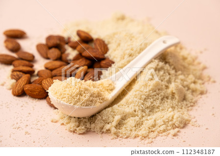 Almond flour and almonds on a beige background Almond flour and almonds on a beige background 112348187
