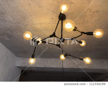 Light bulbs with warm lighting in stylish chandelier on gray concrete ceiling Light bulbs with warm lighting in stylish chandelier on gray concrete ceiling 112348299