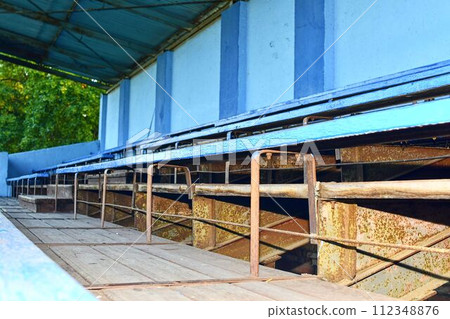 Old grandstand seats. Vintage tone. Old blue wooden grandstand stadium Old grandstand seats. Vintage tone. Old blue wooden grandstand stadium 112348876