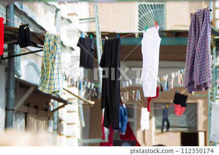 The linen dries on the street on ropes. Drying clothes on the street in the old town. 112350174