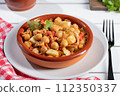 Close up. Ropa vieja, typical Canarian dish of chickpeas stew on earthenware casserole on white table. 112350337