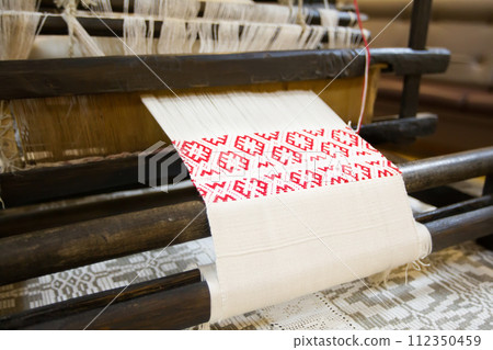 An old machine for weaving towels. Spinning machine. The Belarusian Towel. Making a towel An old machine for weaving towels. Spinning machine. The Belarusian Towel. Making a towel 112350459