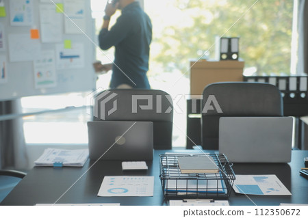Laptop on a desk in an open financial office. 112350672