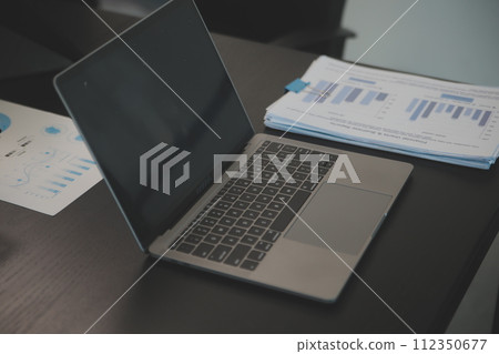 Laptop on a desk in an open financial office. Laptop on a desk in an open financial office. 112350677
