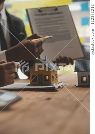 Real estate agent and Sales manager team analysis pricing of rental lease contract of sale purchase agreement, concerning mortgage loan offer for and house insurance. 112351218
