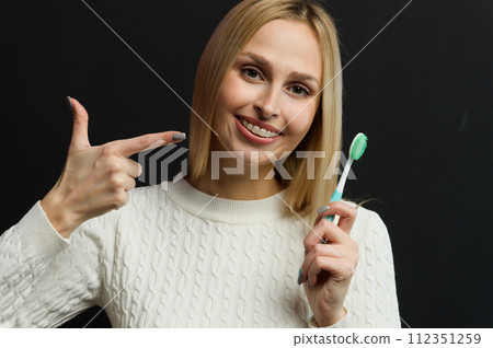 Young beautiful woman points her finger at the toothbrush. 112351259