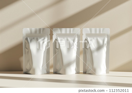 Three white doypack bags on shelf with shadows from window light 112352011