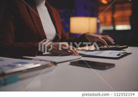 Business woman using calculator for do math finance on wooden desk in office and business working background, tax, accounting, statistics and analytic research concept Business woman using calculator for do math finance on wooden desk in office and business working background, tax, accounting, statistics and analytic research concept 112352154