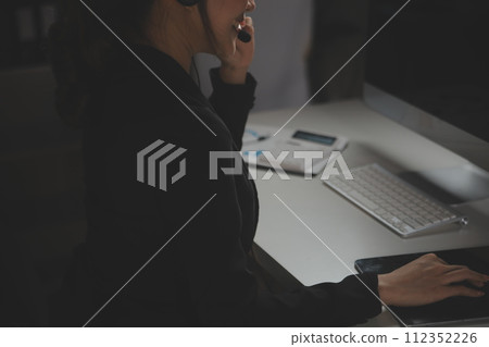 Young woman working in call centre, surrounded by colleagues Young woman working in call centre, surrounded by colleagues 112352226