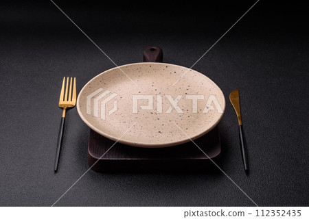 Cutlery fork, knife and spoon on a dark textured concrete background 112352435