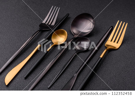 Cutlery fork, knife and spoon on a dark textured concrete background 112352458