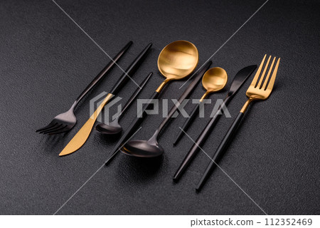 Cutlery fork, knife and spoon on a dark textured concrete background 112352469