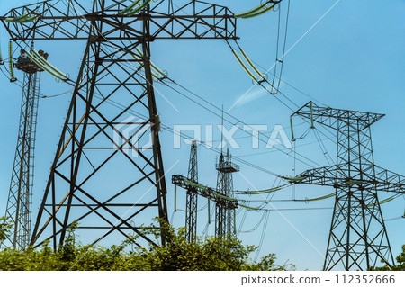 High voltage towers with sky background. Power line support with wires for electricity transmission. High voltage grid tower with wire cable at distribution station. Energy industry, energy saving 112352666