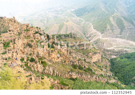 Dagestan Gamsutl. Ancient ghost town of Gamsutl old stone houses in abandoned Gamsutl mountain village in Dagestan, Abandoned etnic aul, summer landscape. Dagestan Gamsutl. Ancient ghost town of Gamsutl old stone houses in abandoned Gamsutl mountain village in Dagestan, Abandoned etnic aul, summer landscape. 112352945