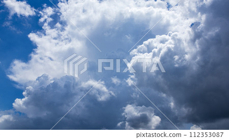 Cumulonimbus clouds appear in the midsummer blue sky 112353087