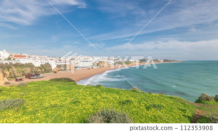 Wide sandy beach and Atlantic ocean in city of Albufeira timelapse. Algarve, Portugal 112353908