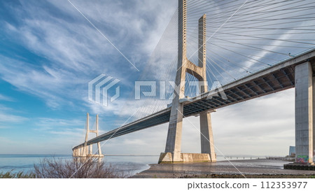 Vasco da Gama bridge timelapse hyperlapse with water in river and blue cloudy sky. Lisbon, Portugal. 112353977