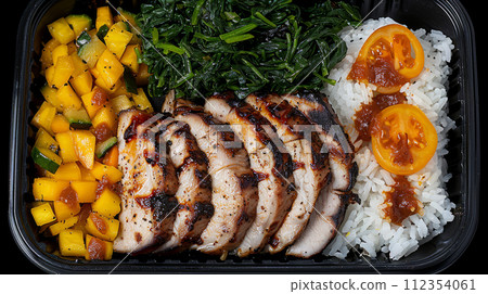 Deliciously prepared meal with juicy grilled chicken, mango salsa, and fresh spinach on bed of rice. 112354061
