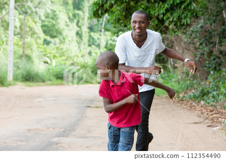 father and son having fun running outside 112354490