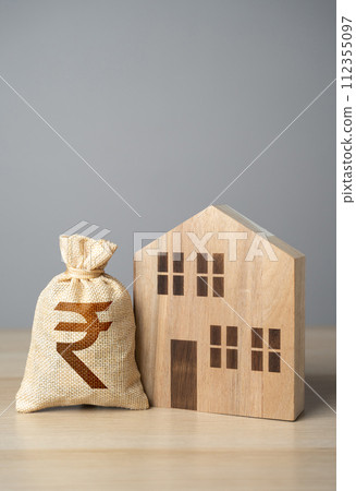 Wooden house figure and indian rupee money bag. Taxes. Property value appraisal. Make a deal. Property Insurance. Housing prices. Buying and selling real estate. Wooden house figure and indian rupee money bag. Taxes. Property value appraisal. Make a deal. Property Insurance. Housing prices. Buying and selling real estate. 112355097