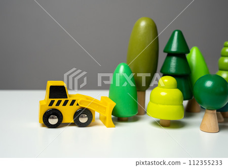 Destruction of forests and trees. Deforestation harms the environment and natural diversity. Protection of natural resources. Save trees from being cut down. A bulldozer demolishes a forest 112355233