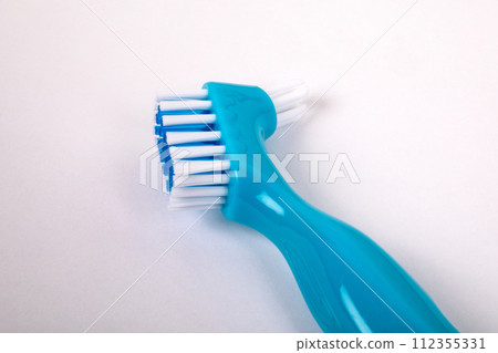 Denture toothbrush on a white background. Effective cleaning of teeth and gums 112355331