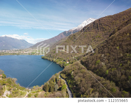 Swiss mountain lake in summer surrounded by lush green meadows and alpine peaks. Swiss mountain lake in summer surrounded by lush green meadows and alpine peaks. 112355665