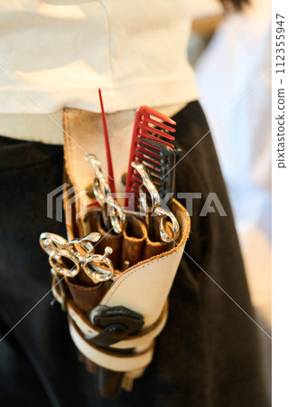 Hairdresser's scissors on her waist Hairdresser's scissors on her waist 112355947