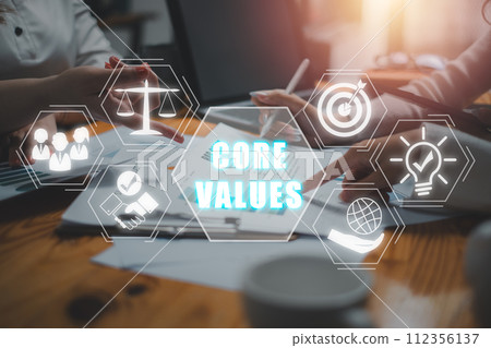 Core values concept, Business team analyzing income charts and graphs on office desk with core values icon on virtual screen. Core values concept, Business team analyzing income charts and graphs on office desk with core values icon on virtual screen. 112356137